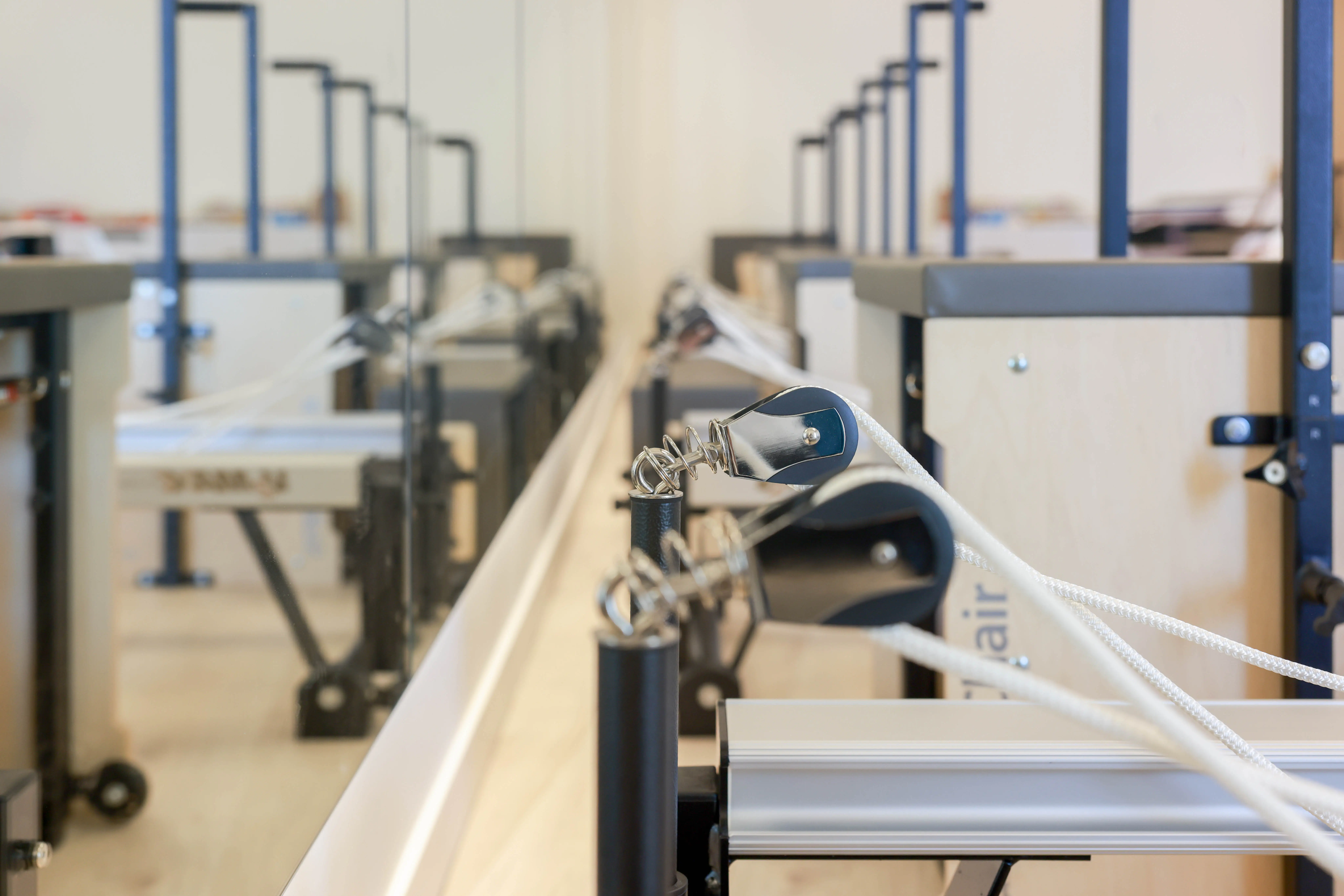 Elin Pilates studio — row of professional Pilates chairs along a mirrored wall